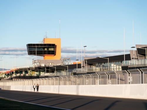 Two walkers walking up Pit Straight on the Mount Panorama Racing Circuit - Australian Stock Image