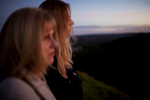 Two women at a lookout at dusk - Australian Stock Image