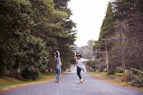 Two women dancing on empty road - Australian Stock Image