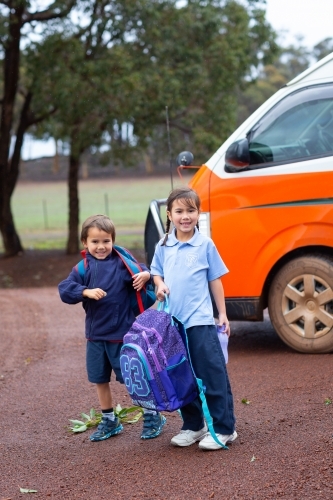 Two young children getting off the school bus - Australian Stock Image