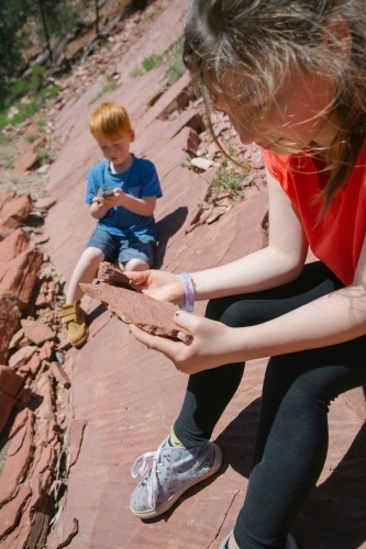 Two young children go looking for fossils in the rocks - Australian Stock Image