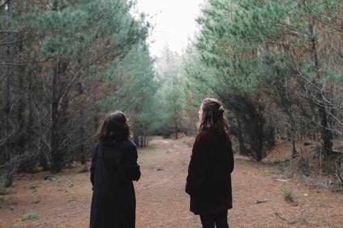 Two Young girls exploring in a forest from behind