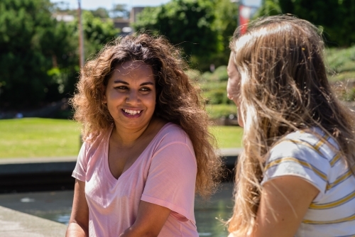 two young women chatting outdoors - Australian Stock Image
