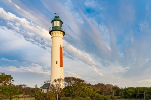 Unusual cloud formation over a tall lighthouse - Australian Stock Image