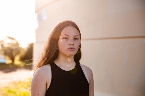 urban sunflare over mixed race teen girl with copy space - Australian Stock Image