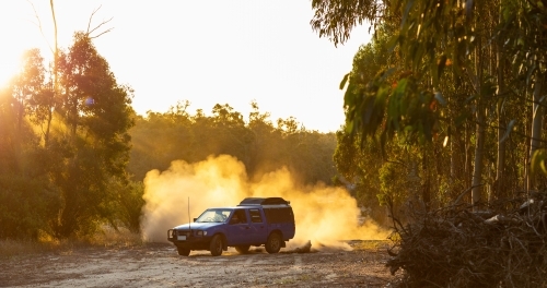 ute doing brodies on dirt track with dust billowing behind - Australian Stock Image