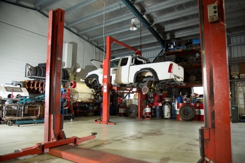 Ute lifted in hoist for repairs in a mechanic workshop