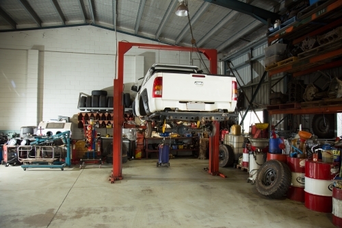 Ute raised for repairs in a mechanic workshop - Australian Stock Image