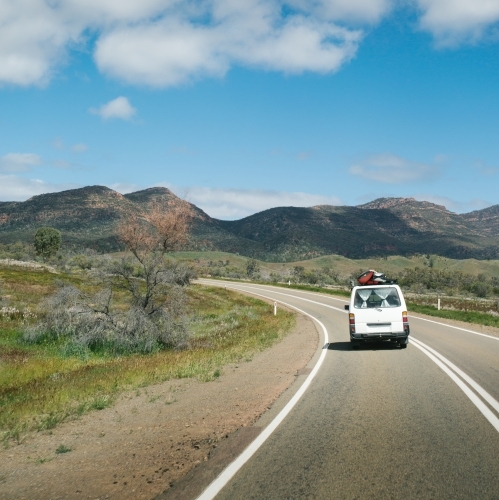 Van driving along a rural outback road from behind