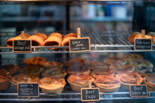 various hot pastries in a warm oven in a bakery - Australian Stock Image