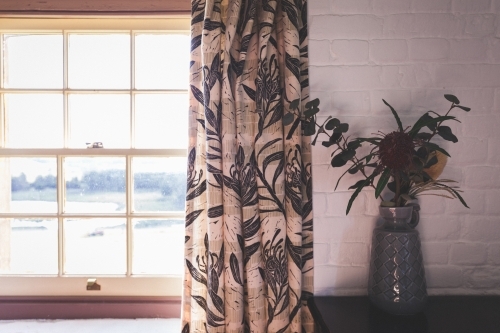 Vase next to window overlooking landscape - Australian Stock Image