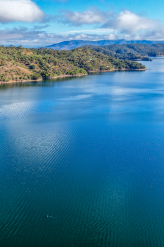 Vertical Aerial view of Glenbawn Dam  leading towards the surrounding mountains - Australian Stock Image