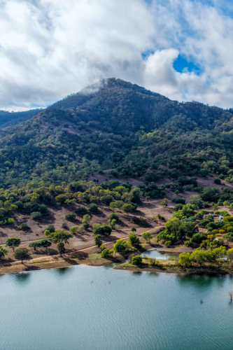 Vertical Aerial view of the Glenbawn Dam shoreline with a cloudy sky over the surrounding mountains - Australian Stock Image