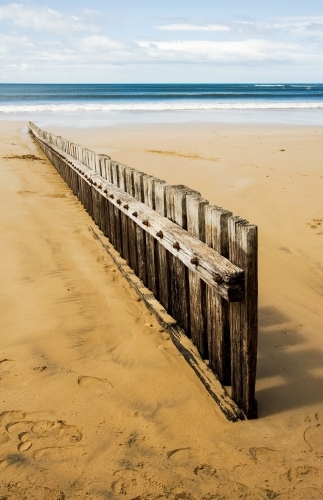 Vertical aspect of groyne leading towards shoreline - Australian Stock Image