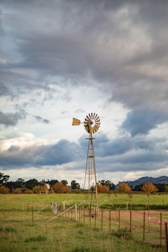 Vertical image of old windmill on rural farm on cloudy day - Australian Stock Image