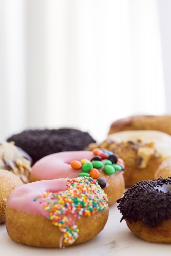 Vertical shot of pink, and black topped donuts - Australian Stock Image