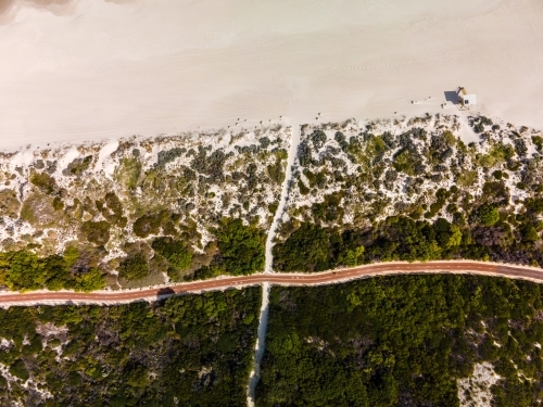 vertical shot of Summers in Perth with white sand, green bushes. and a road - Australian Stock Image