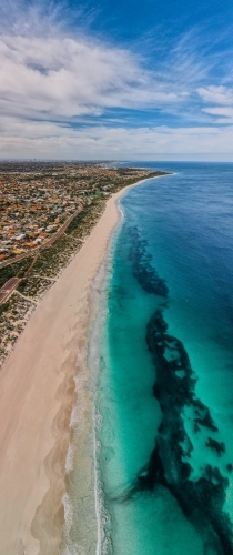 vertical shot of Summers in Perth with white sand shoreline, green grass and ocean water and clouds - Australian Stock Image