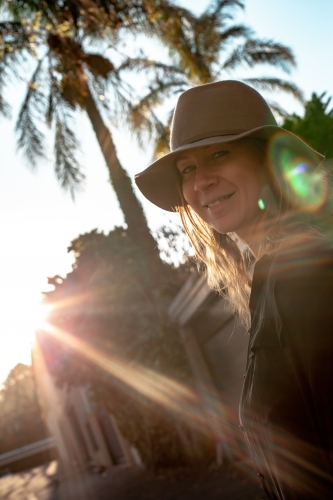 vertical shot of woman with sunlight and trees in the background - Australian Stock Image