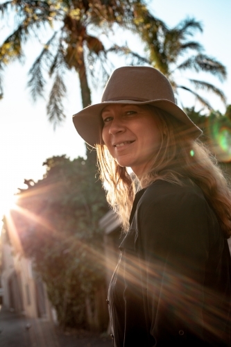 vertical shot of woman with sunlight and trees in the background - Australian Stock Image