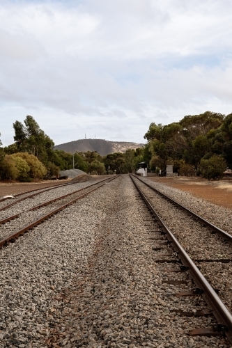 Vertical view looking along railway tracks leading out of country town - Australian Stock Image