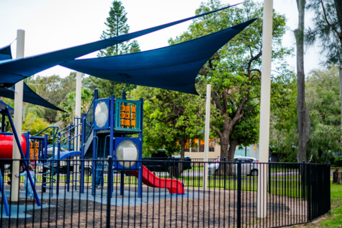vibrant playground shaded by large sails in a park - Australian Stock Image