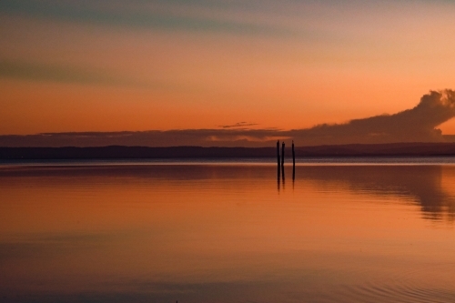Vibrant sunset sky over Tuggerah Lake from Canton Beach on the Central Coast in Toukley, NSW - Australian Stock Image