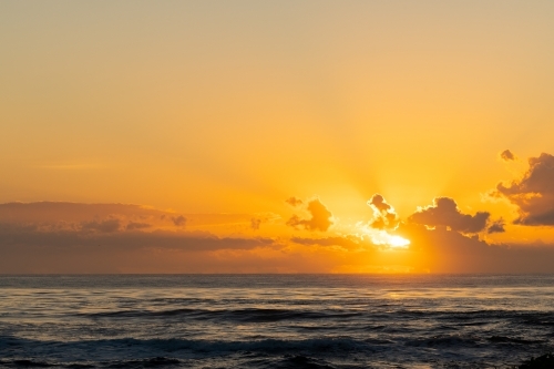Vibrant yellow sunrise over the ocean at Brunswick Heads, NSW - Australian Stock Image