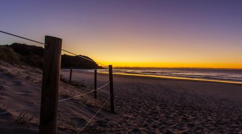view across sandy beach towards sunset