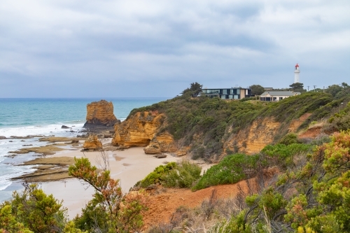 view along coastline to lighthouse and houses - Australian Stock Image