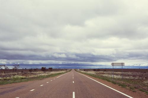 View down a straight flat sealed road in a remote location - Australian Stock Image