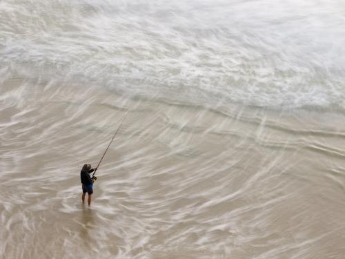 View from above of a Fisherman beach fishing - Australian Stock Image