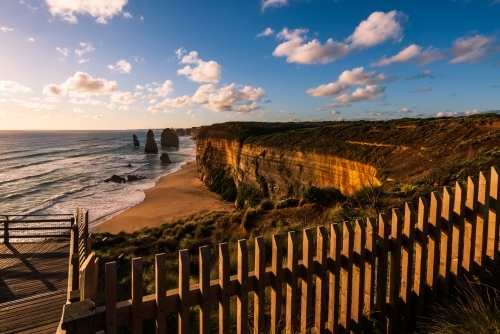 View from fenced lookout of coastal monoliths known as The Twelve Apostles, in beautiful the sunset - Australian Stock Image