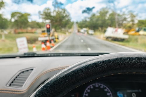 View from inside vehicle stopped at red light at roadworks in the country - Australian Stock Image