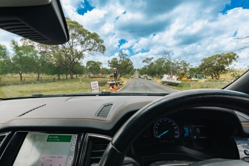 View from inside vehicle stopped at red light at roadworks in the country - Australian Stock Image