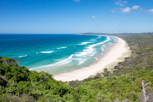 view from Lighthouse Rd over Tallows Beach and Cape Byron in Byron Bay, New South Wales - Australian Stock Image