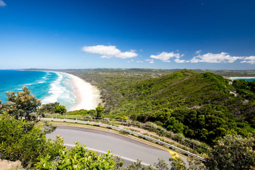 view from Lighthouse Rd over Tallows Beach and Cape Byron in Byron Bay, New South Wales - Australian Stock Image