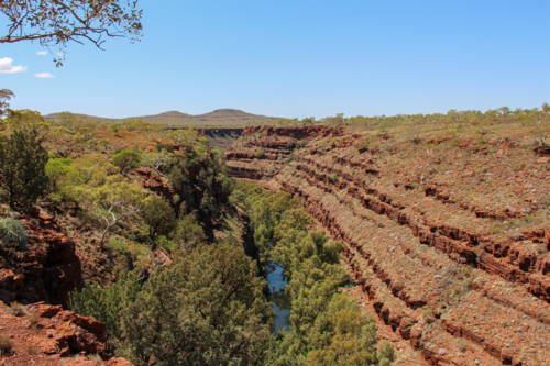 View looking out onto a red rock layered gorge - Australian Stock Image