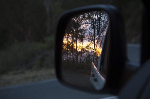 View of a sunset in a car mirror