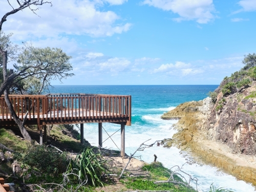 View of beach boardwalk over blue sea - Australian Stock Image