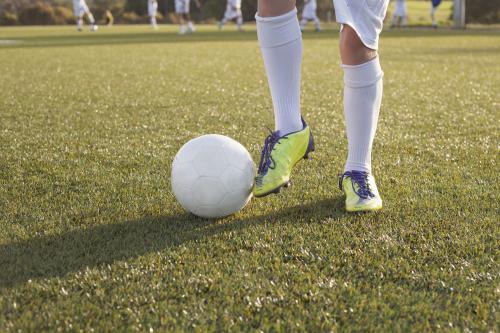 View of boys legs and ball at soccer training - Australian Stock Image