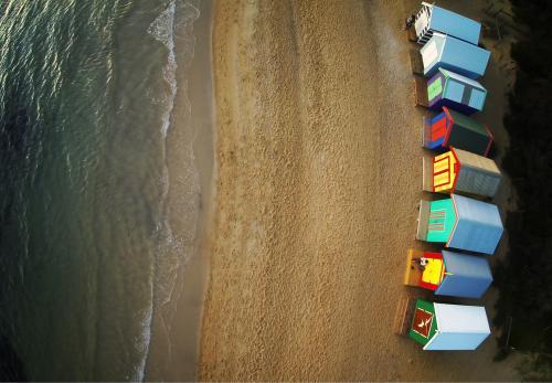 View of colourful beach boxes and ocean from above - Australian Stock Image