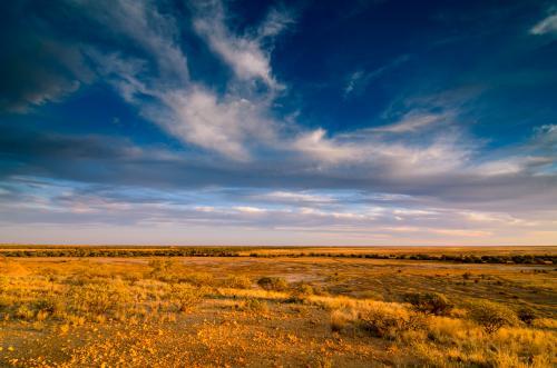 View of desert Channel Country from escarpment with cloud formation - Australian Stock Image