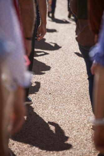 View of the road and people's arms and shadows in ANZAC Day march - Australian Stock Image