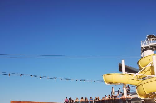 View of water slide, lights and people on the deck of a cruise ship - Australian Stock Image