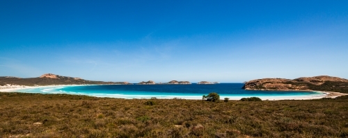View of white beach and turquoise waters of a scenic bay. - Australian Stock Image