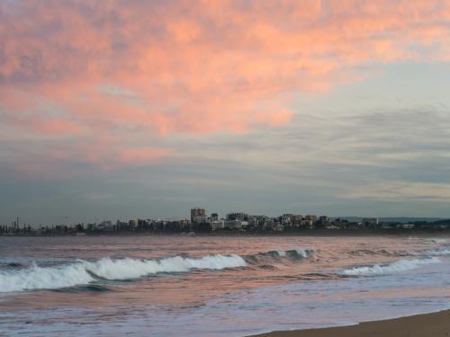 View of Wollongong across the sea at sunset - Australian Stock Image