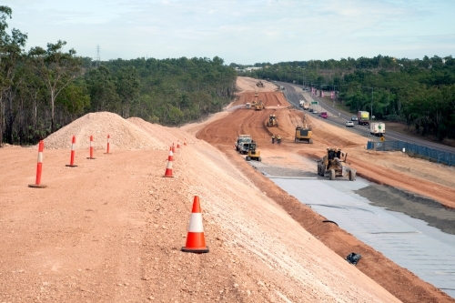 View of workers and heavy machinery on a road construction worksite - Australian Stock Image