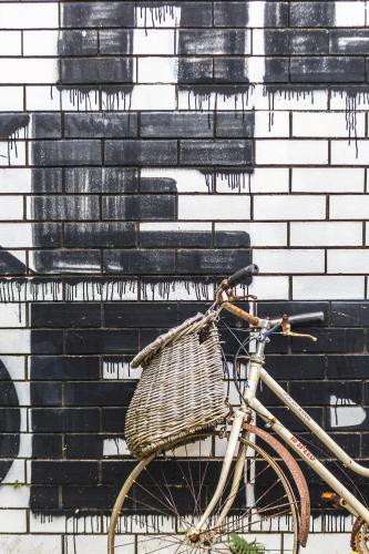 Vintage bike against wall with painted lettering - Australian Stock Image