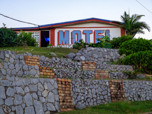 Vintage motel building with red lettering behind tiered stone retaining wall - Australian Stock Image